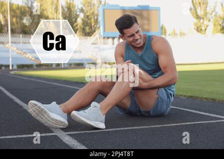 Ruolo del calcio per l'uomo. Uomo che soffre di dolore al ginocchio allo stadio Foto Stock