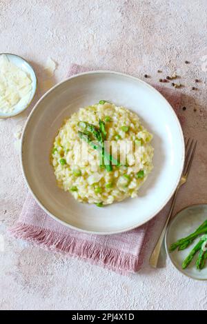 Risotto italiano con asparagi e parmigiano a tavola. Vista dall'alto. Foto Stock