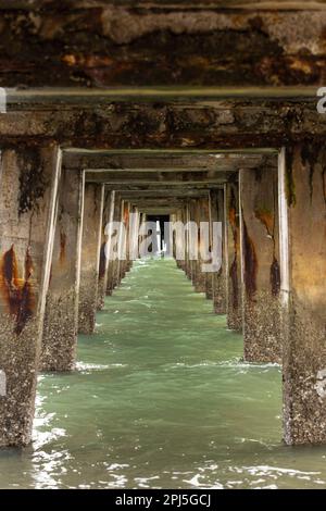 Un molo soleggiato che si affaccia sull'oceano, circondato dalle acque Foto Stock