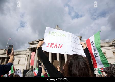 Manifesti, bandiere e messaggi sono tenuti mentre i partecipanti si riuniscono a sostegno della libertà per le donne in Iran dopo la morte di Mahsa Amini a Londra. Foto Stock