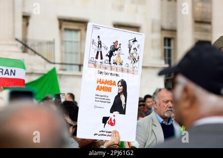 Manifesti, bandiere e messaggi sono tenuti mentre i partecipanti si riuniscono a sostegno della libertà per le donne in Iran dopo la morte di Mahsa Amini a Londra. Foto Stock