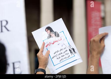 Manifesti, bandiere e messaggi sono tenuti mentre i partecipanti si riuniscono a sostegno della libertà per le donne in Iran dopo la morte di Mahsa Amini a Londra. Foto Stock