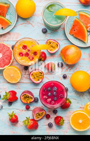 Variazione di frullati e bevande rinfrescanti con frutta fresca per l'estate calda su sfondo blu Foto Stock