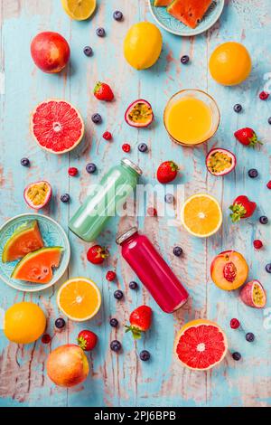 Variazione di frullati e bevande rinfrescanti con frutta fresca per l'estate calda su sfondo blu Foto Stock