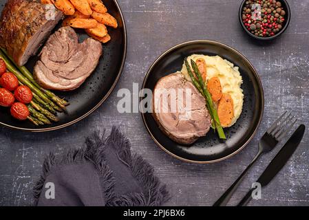 Fotografia alimentare di agnello arrosto, carota, asparagi, pomodoro, condimento, pepe Foto Stock