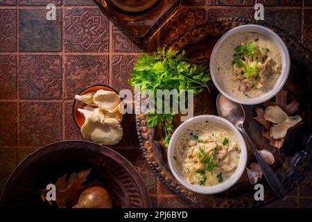 Zuppa di cavolo vegano con funghi di ostriche e verdure sul vecchio tavolo da cucina Foto Stock