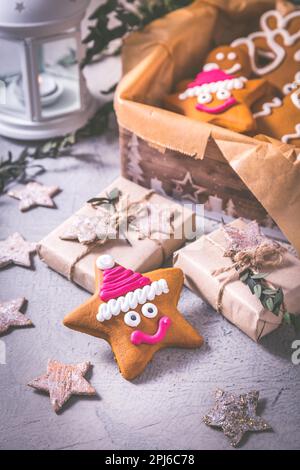 Biscotti di pan di zenzero per Natale in scatola di biscotti con stelle e piccoli regali Foto Stock