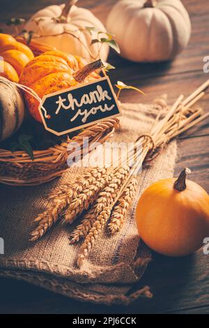 Rendimento di grazie - la vita morta con zucche, orecchie e foglie d'autunno su sfondo di legno Foto Stock
