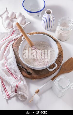Farina e uovo con ingredienti da forno e utensili da cucina Foto Stock