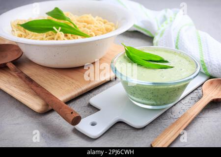 Spaghetti con salsa di aglio selvatico fatta in casa (ramson - allium ursinum) in ciotola Foto Stock