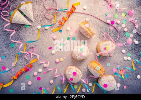 Berliner tradizionale per carnevale e festa. Krapfen tedesco o ciambelle con ruscelli e confetti. Immagine colorata del carnevale o del compleanno Foto Stock