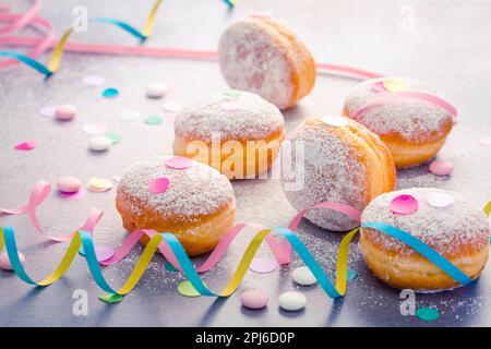 Berliner tradizionale per carnevale e festa. Krapfen tedesco o ciambelle con ruscelli e confetti. Immagine colorata del carnevale o del compleanno Foto Stock