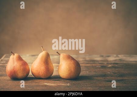 Pere fresche mature su tavola in legno in stile vintage. Raccolto autunnale Foto Stock