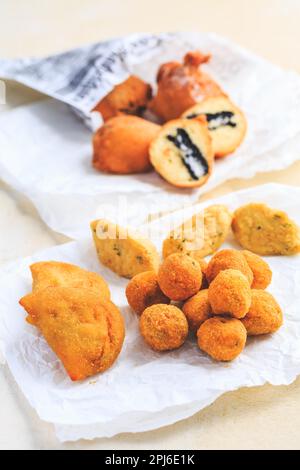 Finger food e Street food - assortimento di palle di riso Arancini, palle di curd fritte, torte di merluzzo Foto Stock