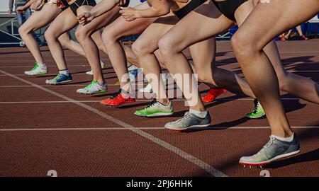 gambe atlete in running spikes scarpe sulla linea di partenza della corsa a metà distanza, sport estivi olimpici Foto Stock