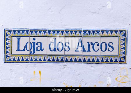 Europa, Portogallo, Obidos. Aprile 15, 2022. Tipiche piastrelle di ceramica con il nome di negozio, 'The Arches Shop.'. Foto Stock