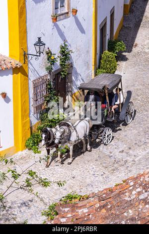 Europa, Portogallo, Obidos. Aprile 16, 2022. Turista in un carro trainato da cavalli in Obidos. Foto Stock