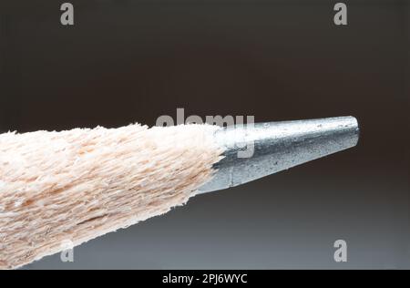 Macro estremo dettaglio della punta di una matita con filo di grafite affilato e albero di legno iniziale come concetto per la scuola di scrittura universsi Foto Stock