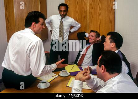 1996 STORICO PICCOLO GRUPPO DI MULTI ETHNIC UFFICIO LAVORATORI RIUNIONE INTORNO AL TAVOLO Foto Stock