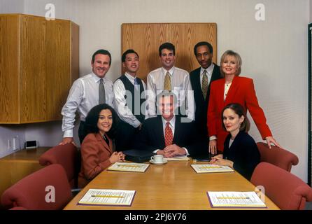 1996 STORICI LAVORATORI DI UFFICI MULTI ETHNIC SI RIUNISCONO INTORNO AL TAVOLO Foto Stock