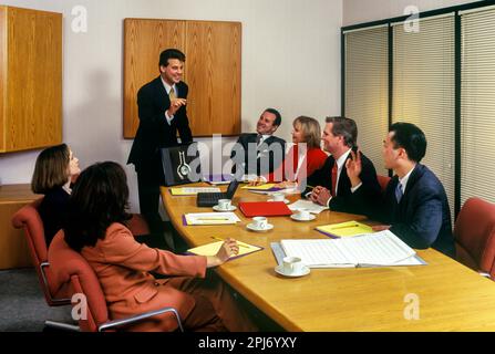 1996 STORICI IMPIEGATI CHE SI RIUNISCONO INTORNO AL TAVOLO Foto Stock