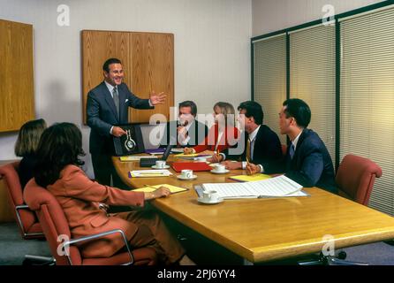 1996 STORICI IMPIEGATI CHE SI RIUNISCONO INTORNO AL TAVOLO Foto Stock