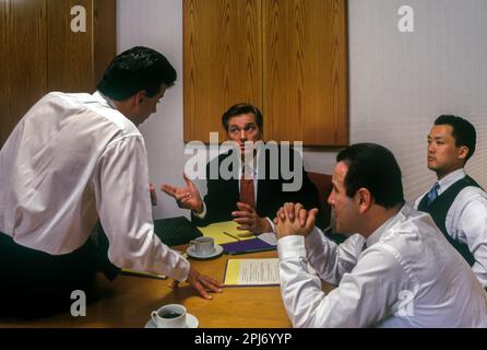 1996 STORICI IMPIEGATI CHE SI RIUNISCONO INTORNO AL TAVOLO Foto Stock
