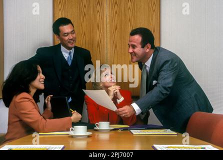 1996 STORICI IMPIEGATI CHE SI RIUNISCONO INTORNO AL TAVOLO Foto Stock