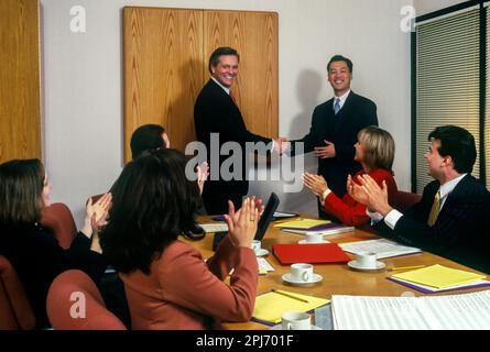 1996 STORICO HANDSHAKE IMPIEGATI RIUNIONE INTORNO AL TAVOLO Foto Stock