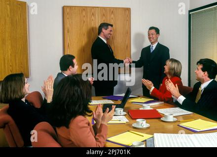 1996 STORICO HANDSHAKE IMPIEGATI RIUNIONE INTORNO AL TAVOLO Foto Stock