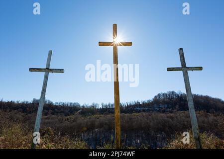 Una vista aerea di tre croci di legno che si erigano su un campo erboso Foto Stock