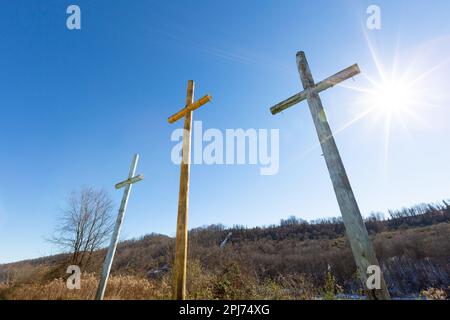 Una vista a basso angolo di tre croce in legno in piedi in un ambiente di campo naturale Foto Stock