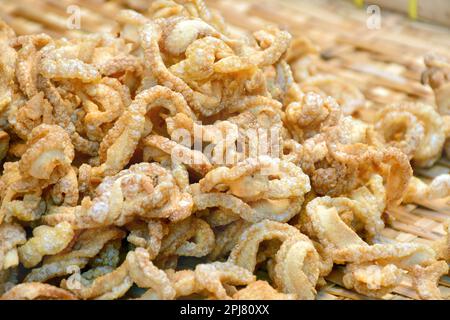 Cibo di strada tailandese, scorze di maiale o pelle di maiale fritta, uno spuntino yummy. Foto Stock