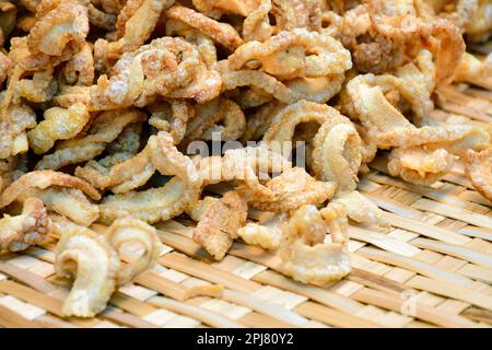 Cibo di strada tailandese, scorze di maiale o pelle di maiale fritta, uno spuntino yummy. Foto Stock