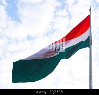 Bandiera dell'India che vola in alto a Connaught Place con orgoglio nel cielo blu, bandiera dell'India che sbatte, bandiera indiana il giorno dell'indipendenza e il giorno della Repubblica dell'India, ti Foto Stock