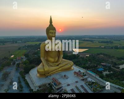 Paesaggio tramonto dietro il grande Buddha d'oro simbolo della Thailandia a wat Muang Ang Thong Thailandia. La statua di Buddha più grande del mondo circondata Foto Stock