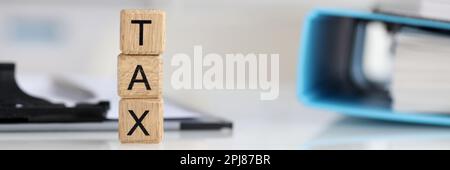 Testo fiscale su cubi di legno su tavola con documenti Foto Stock