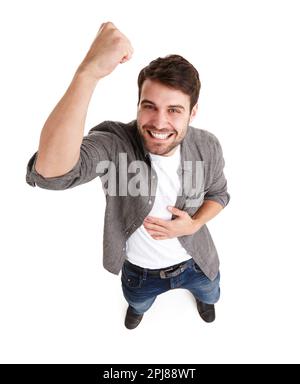 La vittoria è mia. Colpo ad angolo alto di un giovane felice in studio che alza il pugno nella vittoria. Foto Stock