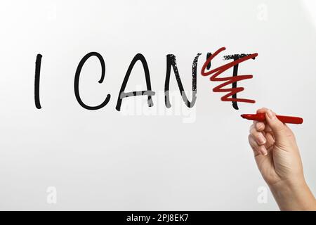 Donna barrata lettera T in frase non posso su sfondo bianco, primo piano. Motivazione e positività Foto Stock