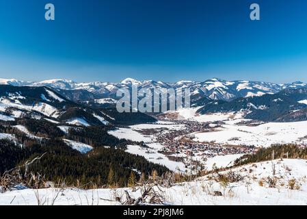 Liptovska Luzna villaggio con Velka Fatra montagna sullo sfondo in Slovacchia durante bella giornata invernale Foto Stock