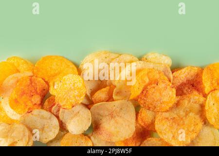 Bordo di patatine isolato su sfondo turchese. Chip perfettamente condito con un aroma appetitoso Foto Stock