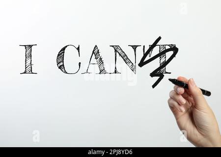 Donna barrata lettera T in frase non posso su sfondo bianco, primo piano. Motivazione e positività Foto Stock