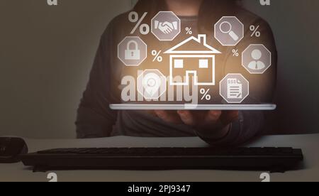 Concetto di prestito ipotecario domestico. Donna che mostra un tablet digitale con interfaccia ipoteca. Contratto di affitto per l'acquisto e la vendita di una casa. Foto Stock