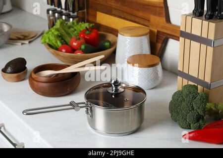 Pentola in metallo, altri utensili da cucina e verdure fresche sul piano di  appoggio in cucina Foto stock - Alamy