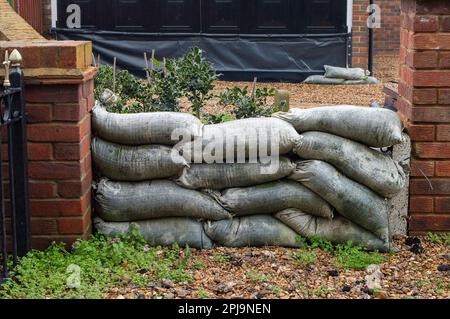 Old Windsor, Berkshire, Regno Unito. 1st aprile 2023. Un proprietario di abitazione ottiene pronto per inondare con i sacchi di sabbia fuori della loro casa e garage. Un allerta alluvione per il Tamigi è stato emesso oggi dall'Agenzia per l'ambiente da Maidenhead a Windsor ed Eton, ma finora, Old Windsor non è stata inclusa nell'allerta alluvione. Credit: Maureen McLean/Alamy Live News Foto Stock