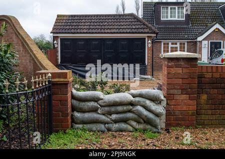 Old Windsor, Berkshire, Regno Unito. 1st aprile 2023. Un proprietario di abitazione ottiene pronto per inondare con i sacchi di sabbia fuori della loro casa e garage. Un allerta alluvione per il Tamigi è stato emesso oggi dall'Agenzia per l'ambiente da Maidenhead a Windsor ed Eton, ma finora, Old Windsor non è stata inclusa nell'allerta alluvione. Credit: Maureen McLean/Alamy Live News Foto Stock