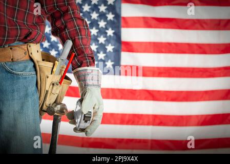 Lavoratore in guanti e cintura portautensili su di noi bandiera sfondo Labor Day mockup Foto Stock