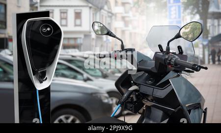 Scooter elettrico con stazione di ricarica su una strada cittadina. Foto di alta qualità Foto Stock