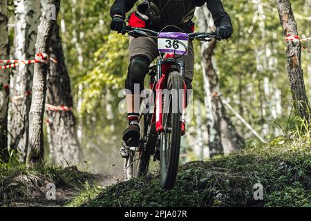 Atleta su discesa in bicicletta su sentiero forestale, corsa in mountain bike DH, giochi di sport estivi estremi Foto Stock