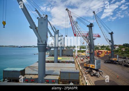 Operazioni con carbone nel porto marittimo. Carico di carbone su portarinfuse. Carico di carbone da parte di gru su navi portarinfuse Foto Stock